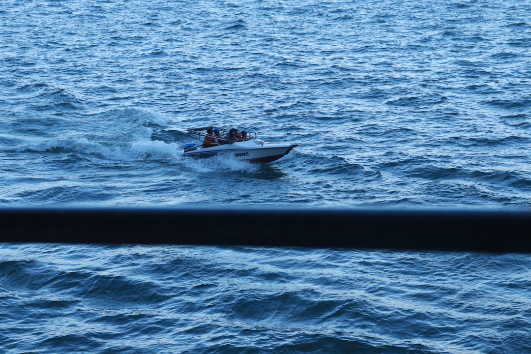 Speedboat afgemeerd in de haven van Labuan Bajo met eilanden op de achtergrond, Flores, Indonesië